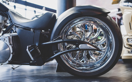 Cropped image of new motorcycle in shop. Motorcycles and accessories in modern motorcycle custom store. Biker stuffの写真素材