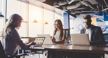 Group of young business people are working together in modern office with laptop, tablet, smart...