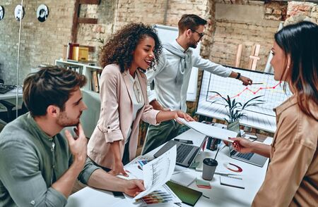 Group of young multiracial business people are working in modern office. Freelancers in coworking place. Creative and stylish youth.の写真素材