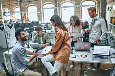 Group of young multiracial business people are working in modern office. Freelancers in coworking place. Creative and stylish youth.の写真素材