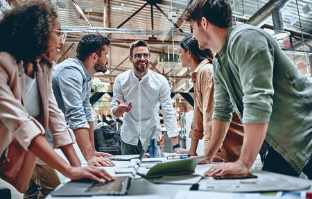 Group of young multiracial business people are working in modern office. Freelancers in coworking place. Creative and stylish youth.の写真素材