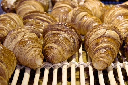 Freshly baked croissants on a wooden gridの写真素材