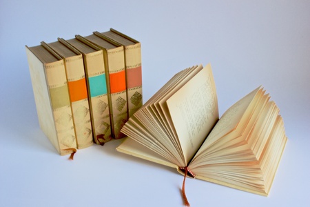 Five books standing in a row and one laying openの写真素材
