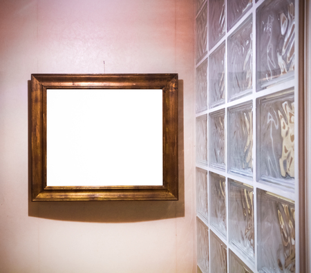 An empty antique golden frame by a glass wall. Interesting red lightingの写真素材
