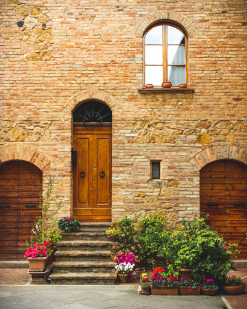 Flowers decorate the entrance of a house in ancient italian townの写真素材