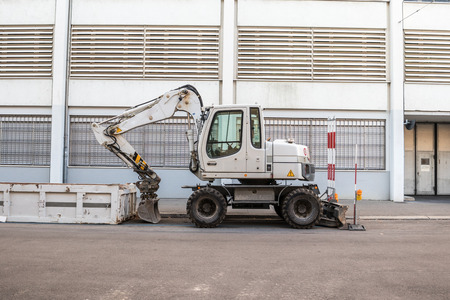 White Machinery in urban setting, white cement wall and roads