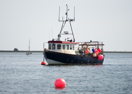 Blue and white fishing boat at anchorの写真素材