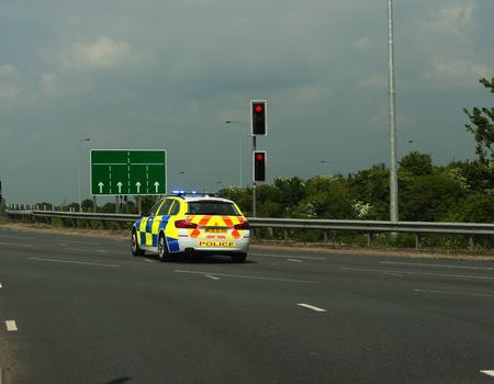 British Police car on emergency call going through a red traffic lightのeditorial素材