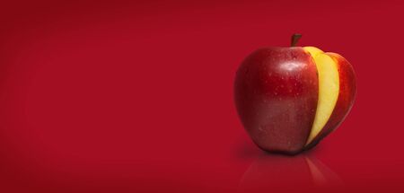 Sliced apple isolated on red backgroundの写真素材