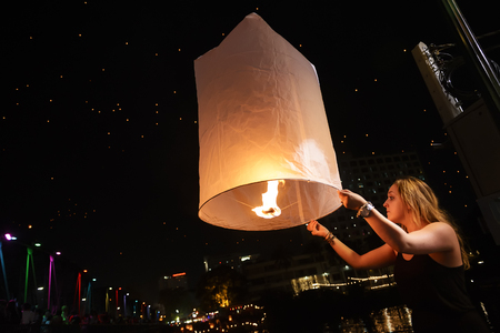 CHIANG MAI, THAILAND - NOVEMBER 3, 2017 : Loy Krathong festival, Unidentified tourist lights floating lanterns made of paper annually Loy Krathong Festival, popular place is the Ping River of the cityのeditorial素材