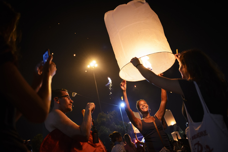 CHIANG MAI, THAILAND - NOVEMBER 3, 2017 : Loy Krathong festival, Unidentified tourist lights floating lanterns made of paper annually Loy Krathong Festival, popular place is the Ping River of the cityのeditorial素材