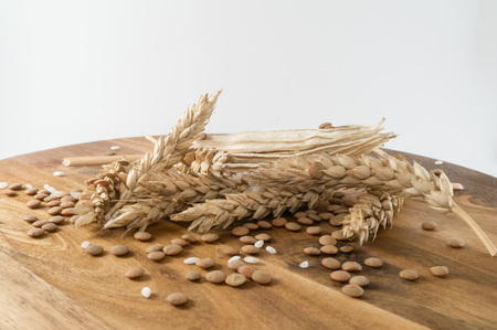 Wheat with cereals on wooden tableの写真素材