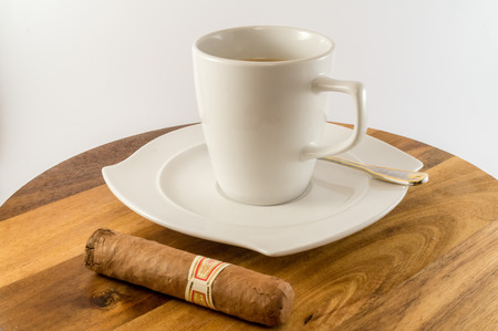 Cup of coffee with cuban cigar besideの写真素材