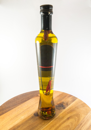 Bottle with olive oil and peppers on white backgroundの写真素材