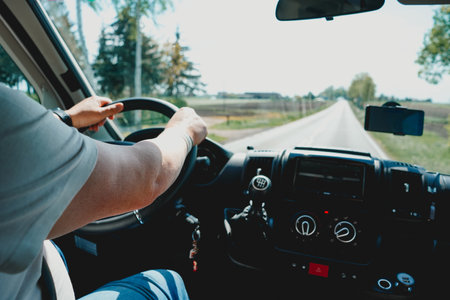 Man driving a car on a country road. Close-up view from the driver's seat.