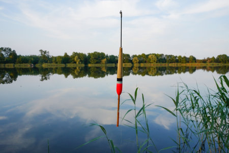 Fishing float in the air over the air. Fishing bobber at the lake in the forest.の写真素材