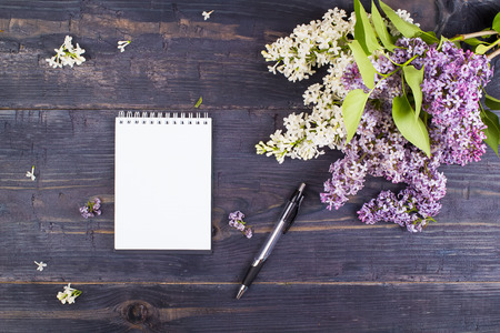 Notebook and lilac on a tableの写真素材