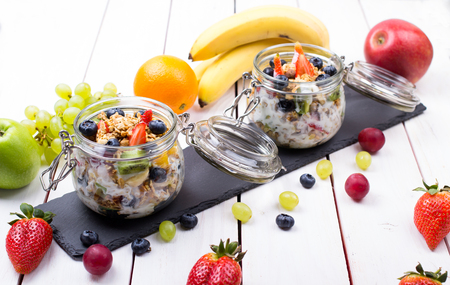 Muesli, fruit, berries in a bowl on an old tableの写真素材