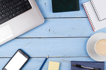 The laptop, phone, coffee, notebook, workplace on a tableの写真素材