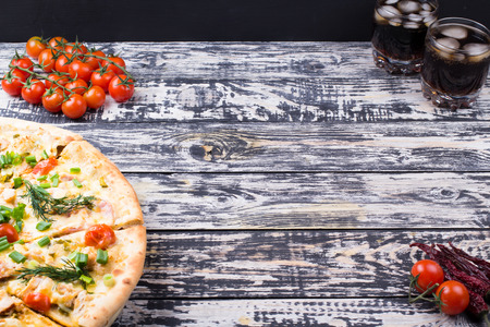 Cherry ham and cheese pizza on an old tableの写真素材