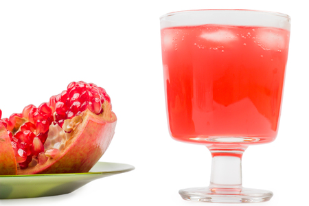 pomegranate in a plate broken and lemonade with ice on a white backgroundの写真素材