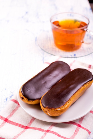 Tea, eclairs and cinnamon on a tableの写真素材