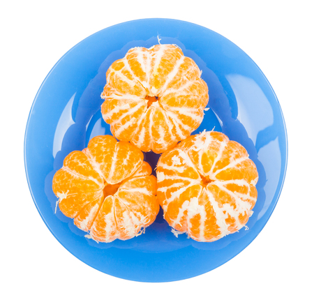 The tangerines peeled in a blue plate on a white backgroundの写真素材