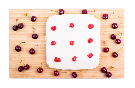 Square cake with cherry on a white backgroundの写真素材
