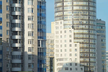 Full color horizontal photo. An urban landscape with white building structures against a blue sky background.の写真素材