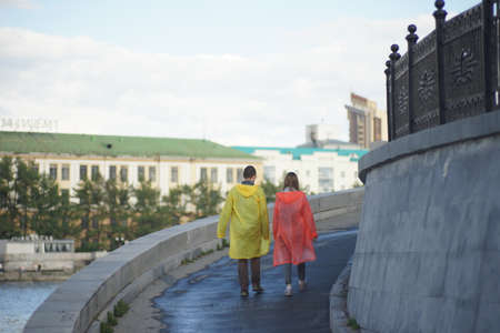 Two young people are walking in a park on the shore.