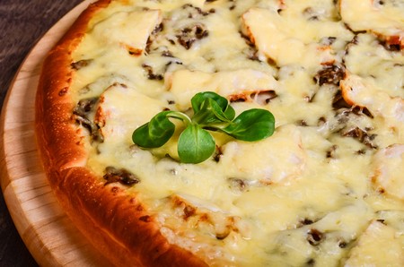 Pizza on a table of dark woodの写真素材