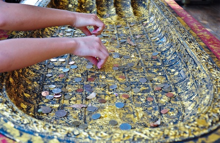 Put down the coinages on the Buddha s foot,Faith of Buddhismの写真素材