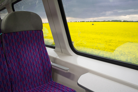 Fields of rapeseed outside the window of the train in the Czech Republic