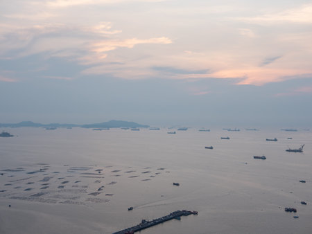 Sea and harbor at sunset with cargo ships.
