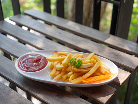 French fries in a plate placed on a wooden table.の写真素材