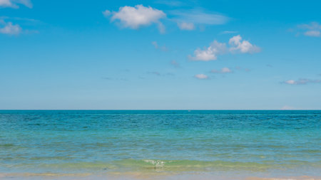 beautiful beach and tropical sea under the blue sky with white cloudsの写真素材