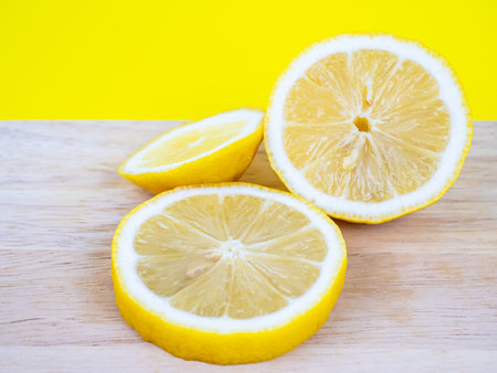 Sliced lemon on wooden table with yellow background, stock photoの写真素材