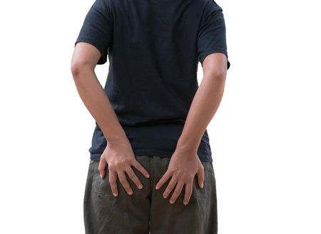 Young man with hand on hip isolated on white background, back viewの写真素材