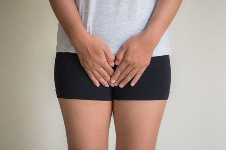 Woman suffering from back pain on grey background. Health care concept.の写真素材