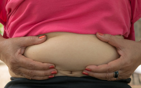 Pregnant woman holding her belly with her hands, closeupの写真素材