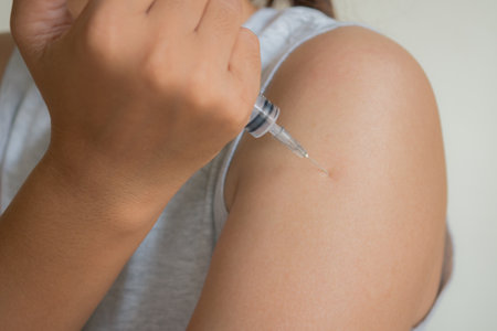 Close up shot of a young woman injecting herself with a syringeの写真素材