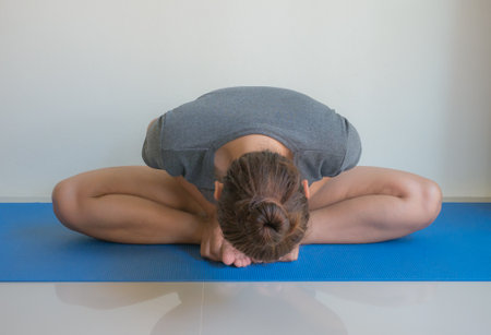 Portrait of a beautiful young woman doing yoga exercise on mat at homeの写真素材