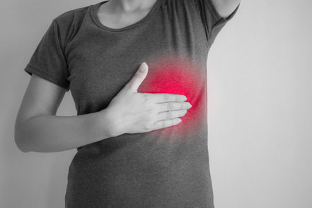 Man holding his chest suffering from pain in his chest. Healthcare and medical concept.の写真素材