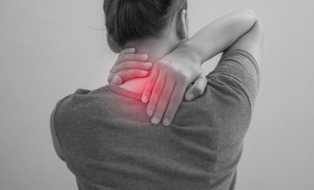 Woman suffering from pain in the neck and shoulder, monochromeの写真素材