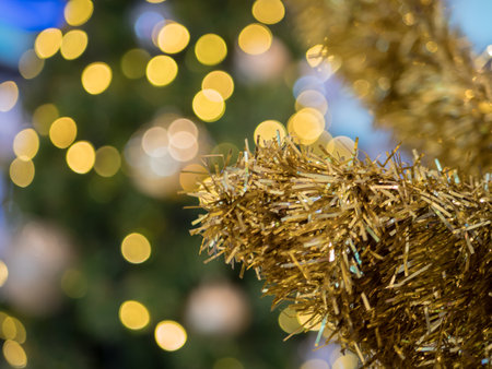 Close Up of bauble hanging from a decorated Christmas tree.の写真素材