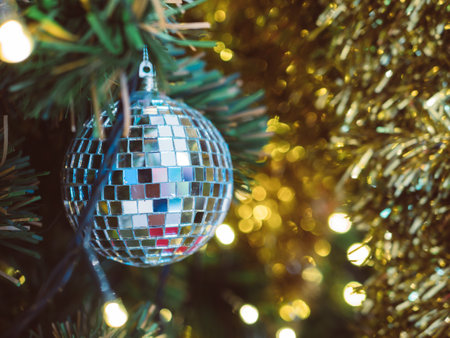 Close Up of bauble hanging from a decorated Christmas tree.の写真素材