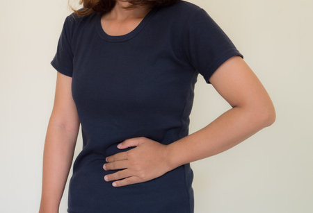 Woman with stomachache on white background. Health care and medical concept.の写真素材