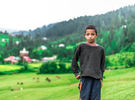 Kullu, Himachal Pradesh, India - August 04, 2018 : Photo of A Himalayan Boy in Green Meadow Surrounded by Deodar Tree in Himalayas, Great Himalayan National Park, Sainj Valley, Shahgarh, Himachal Pradesh, Indiaのeditorial素材