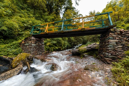 Wooden bridge over waterfall in himalayas - sainj, kullu, himachal, Indiaの写真素材