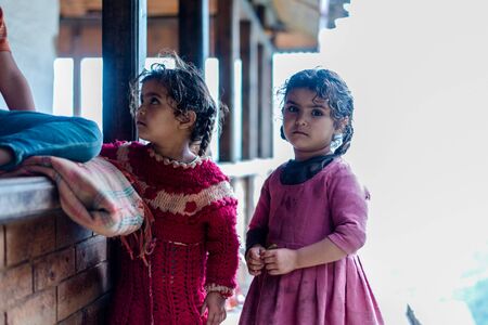 Kullu, Himachal Pradesh, India - August 09, 2018 : Photo of twins girl near her house, on the street in Himalayan village, Indiaのeditorial素材